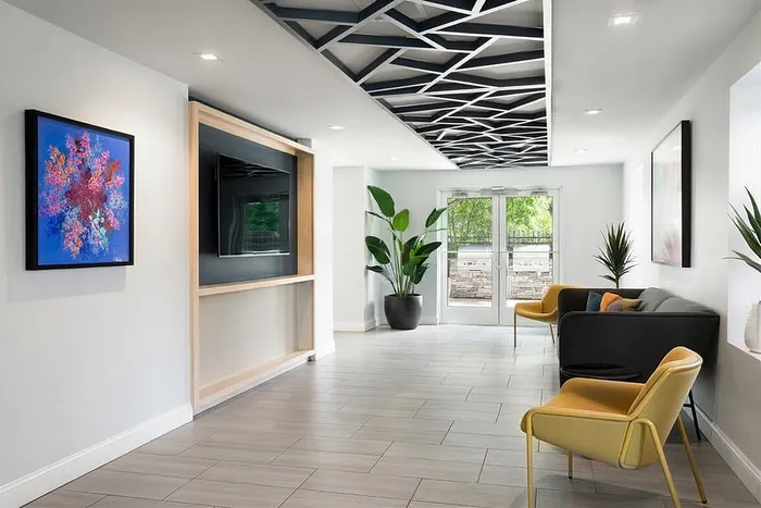 Contemporary lobby with stylish seating, geometric ceiling design, and vibrant artwork, creating a welcoming atmosphere.