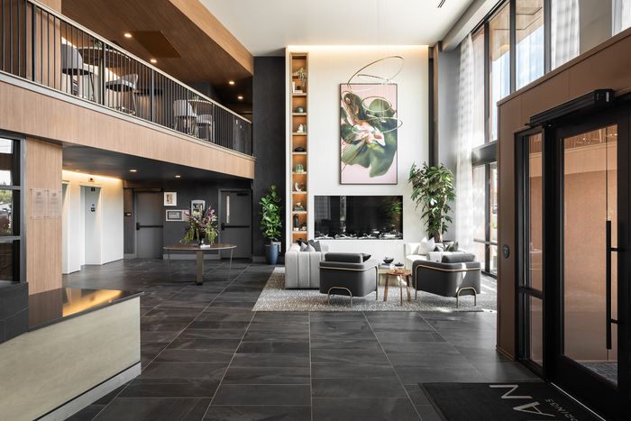 Luxurious lobby with sleek modern design, featuring a striking high ceiling, elegant seating area, and artistic decor.