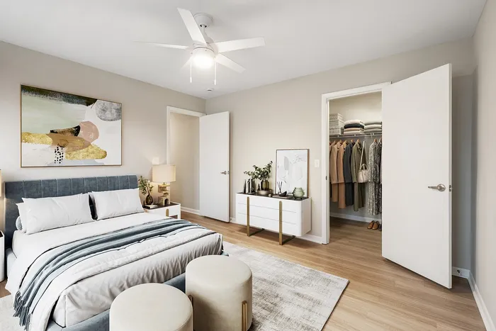Elegant bedroom with modern decor, featuring a spacious walk-in closet and stylish artwork, perfect for a serene living experience.
