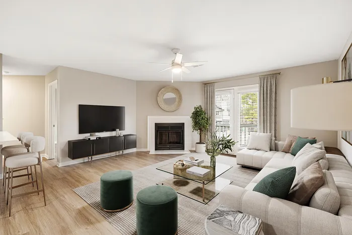 Bright and modern living room with elegant decor, featuring a cozy fireplace, stylish L-shaped sofa, and sleek entertainment center.