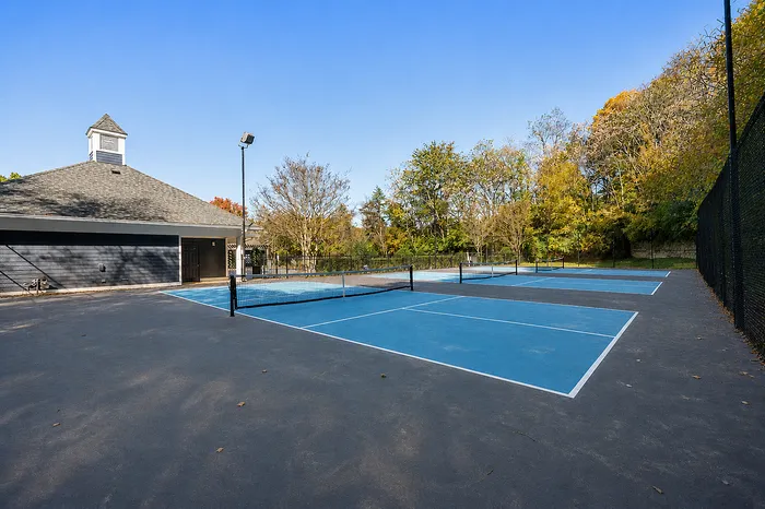 Inviting outdoor tennis court surrounded by lush greenery, perfect for recreational activities and enjoying nature.