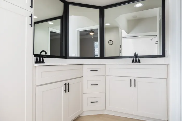 Luxurious modern bathroom with elegant black and white cabinetry and stylish fixtures.