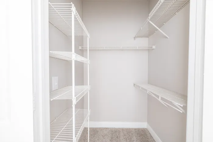 Spacious, well-lit walk-in closet with elegant wire shelving, perfect for organizing your wardrobe.