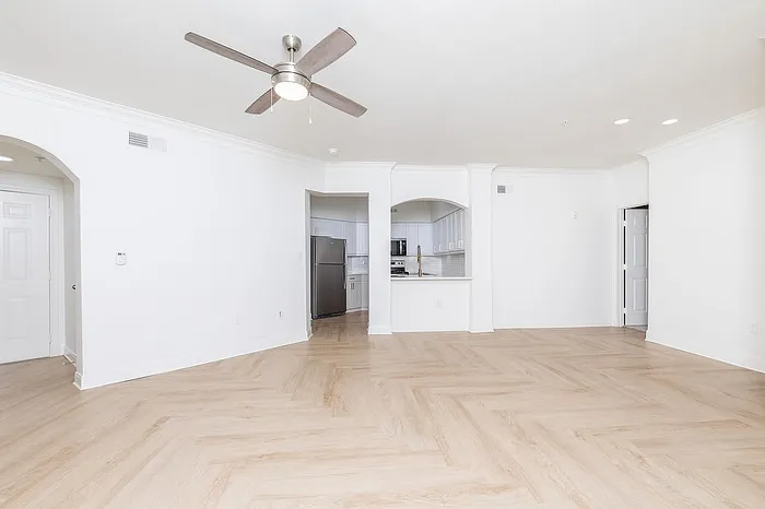 Bright, open-concept living area with elegant hardwood flooring and modern kitchen access.