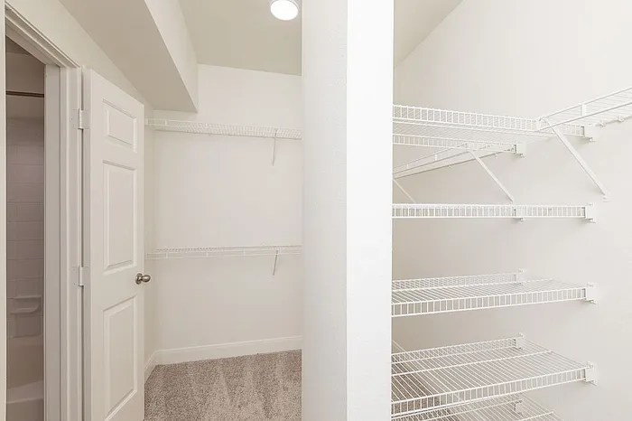 Spacious walk-in closet with abundant shelving and modern design, perfect for organized living.