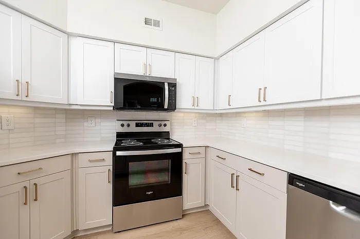 Sleek modern kitchen with pristine white cabinetry, stainless steel appliances, and elegant countertops.