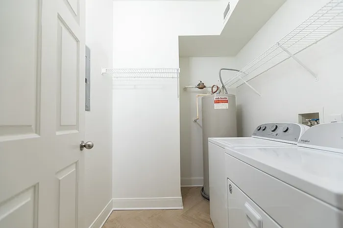 Modern laundry room featuring sleek appliances, ample storage shelves, and contemporary minimalist design.
