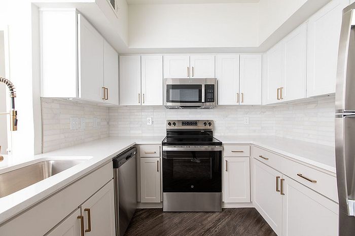 Modern kitchen with sleek white cabinetry, stainless steel appliances, and elegant countertops.