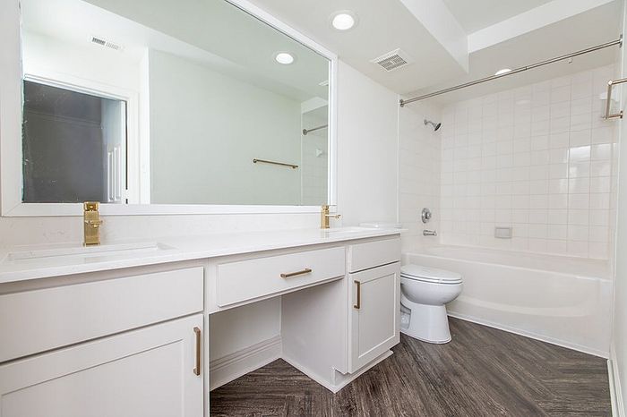 Elegant bathroom with sleek double vanity, modern fixtures, and luxurious bathtub, complemented by chic flooring.