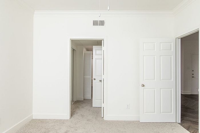 Bright, inviting room with plush carpet and modern doors, perfect for a cozy living space.