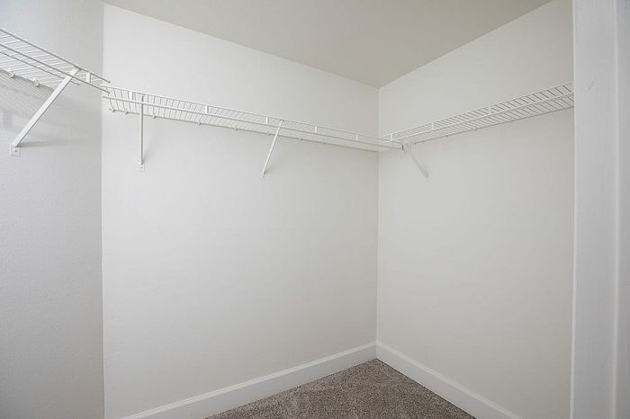 Spacious closet with elegant white wire shelving, perfect for organizing your wardrobe.
