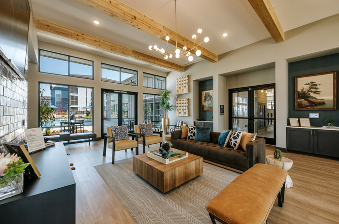 Inviting modern living area with plush seating, chic decor, and large windows overlooking a tranquil outdoor space.