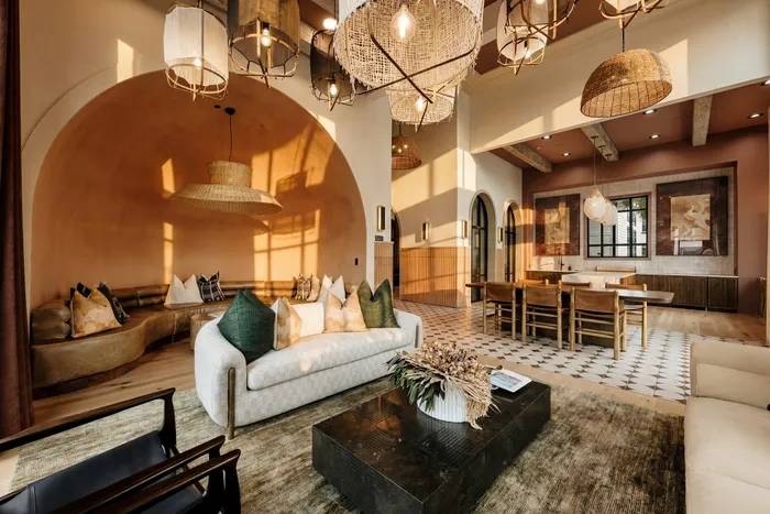Elegant living space bathed in warm sunlight, featuring modern decor, plush seating, and stylish pendant lights with a cozy dining area.