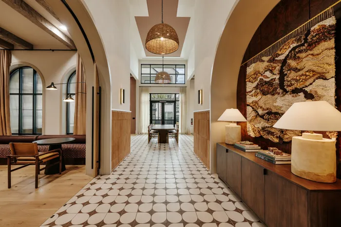 Chic hallway with artistic wall decor, elegant lighting, and panoramic windows leading to a stylish dining area.