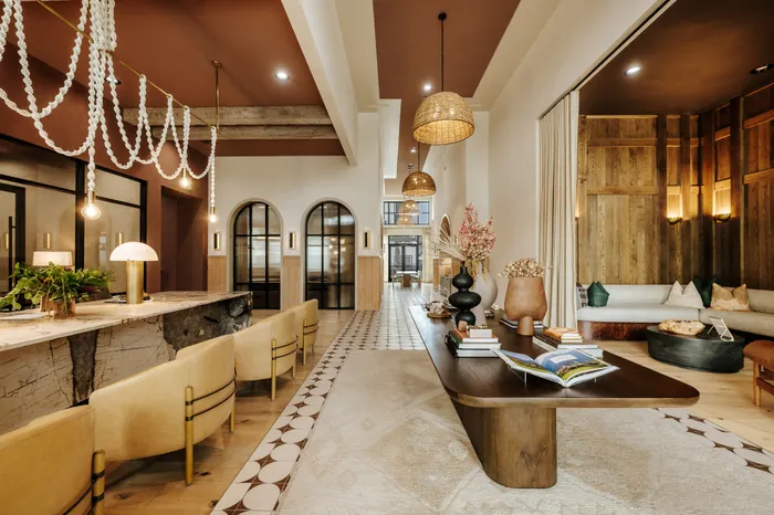 Luxurious open-concept lounge with elegant decor, featuring a chic marble bar, stylish beige seating, and warm ambient lighting.