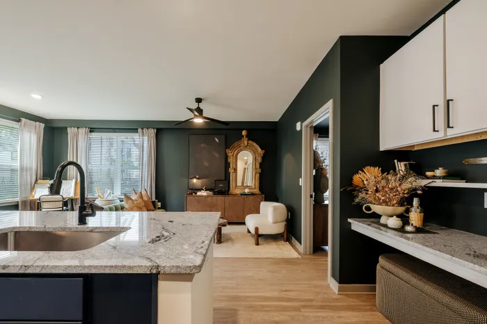 Elegant modern living space featuring a chic gray countertop island, stylish seating area, and large windows enhancing natural light.