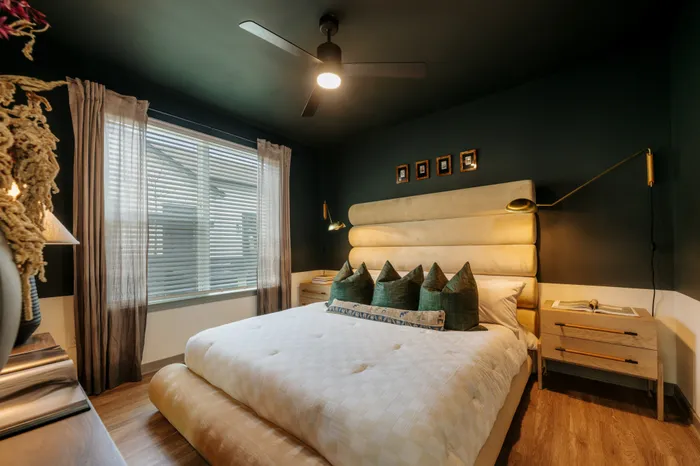 Luxurious bedroom with modern design featuring a plush bed, stylish lighting, and large window with elegant curtains.