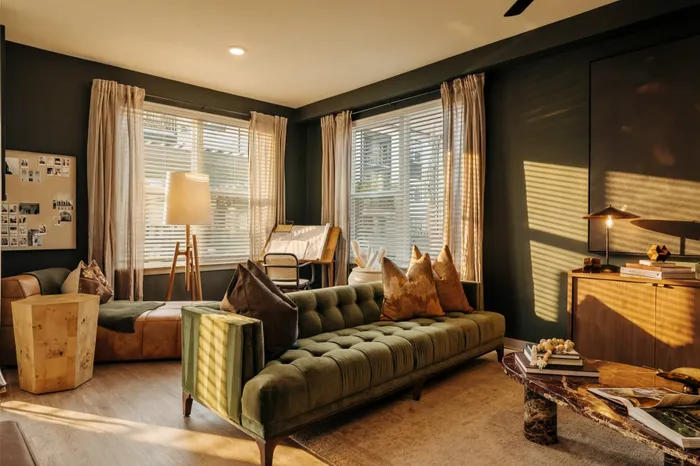 Inviting living room with a plush green sofa, warm lighting, and elegant decor, creating a cozy and stylish atmosphere.