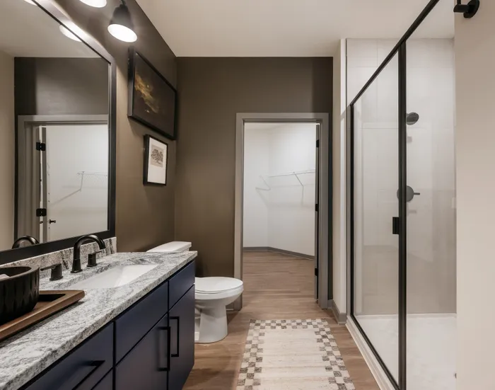Elegant modern bathroom with a spacious shower, stylish double vanity, and chic lighting fixtures.