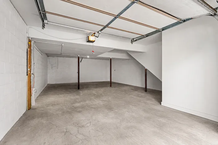 Spacious garage with polished concrete floors, featuring ample room for storage or parking in a modern, well-lit space.