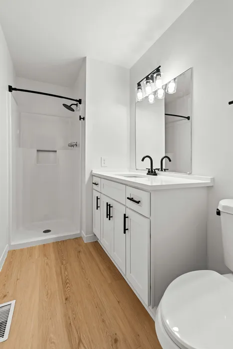 Bright and modern bathroom with sleek fixtures, elegant vanity, and a stylish shower area.