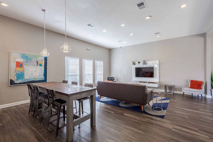 Modern living room with sleek hardwood floors, ambient lighting, and artistic decor, offering a cozy and elegant atmosphere.