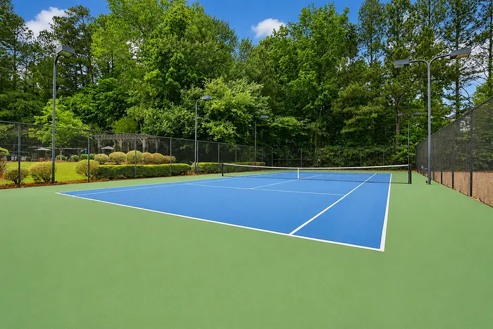 Vibrant outdoor tennis court surrounded by lush greenery, perfect for active lifestyle.