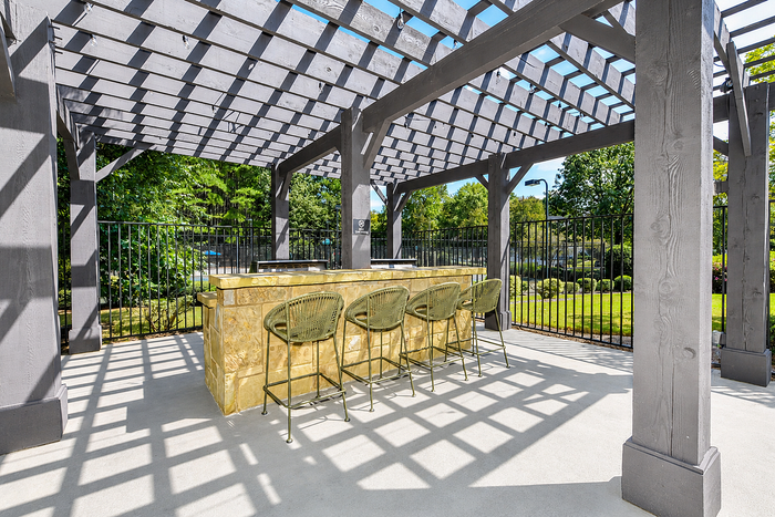 Charming outdoor space with stylish pergola and elegant seating, perfect for entertaining and enjoying the lush greenery.
