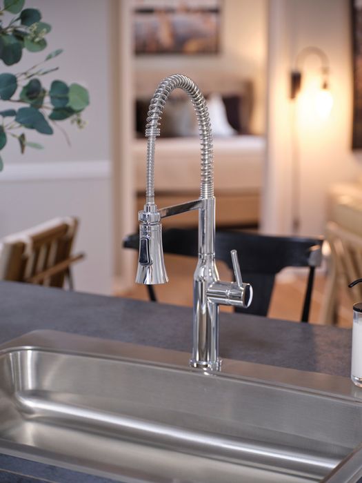 Elegant kitchen scene showcasing a modern chrome faucet with a sleek design, creating a sophisticated ambiance.