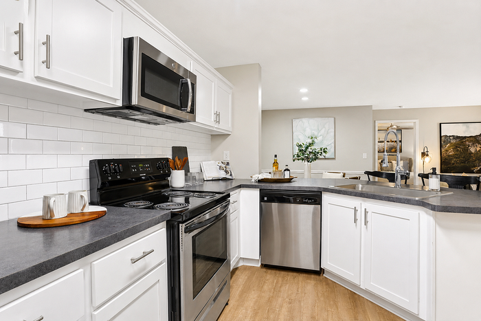 Elegant, modern kitchen with sleek stainless steel appliances, crisp white cabinetry, and contemporary finishes for a stylish culinary experience.