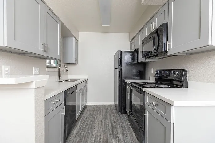 Modern kitchen with sleek gray cabinets, stainless steel appliances, and elegant countertops.