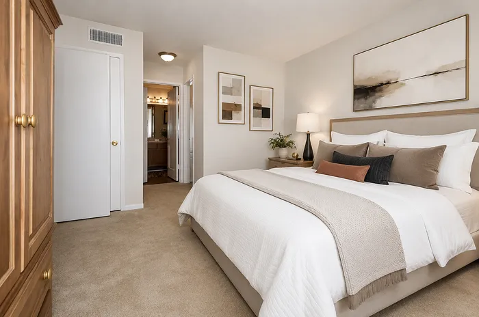 Inviting bedroom with elegant decor, featuring plush bedding, warm lighting, and stylish artwork. A peaceful retreat that combines comfort and modern design.