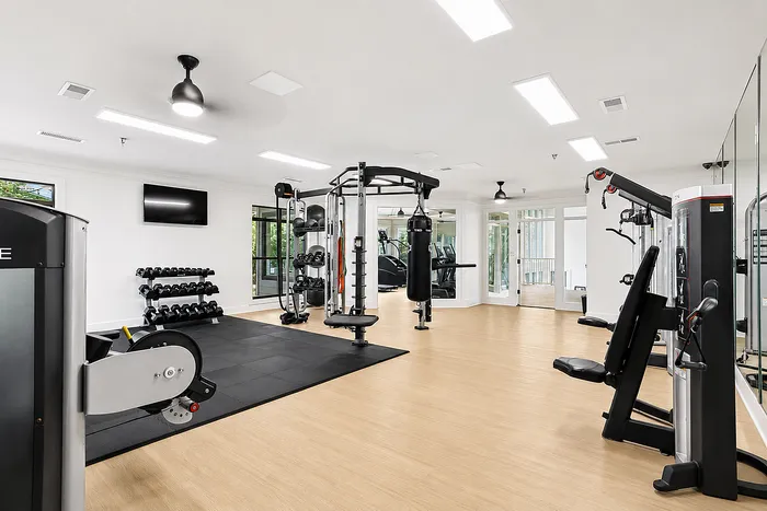Modern and spacious gym equipped with state-of-the-art fitness machines, free weights, and a punching bag, ideal for an invigorating workout.