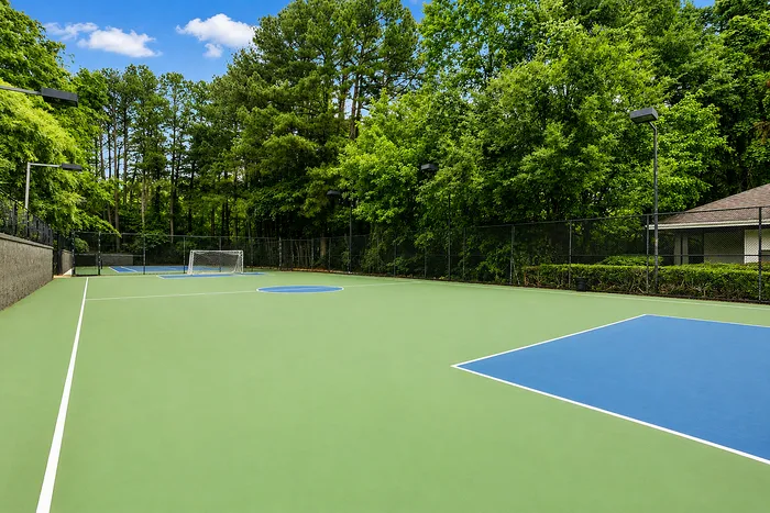 Vibrant outdoor sports court surrounded by lush greenery, perfect for recreational activities in a serene setting.