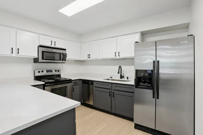 Modern kitchen featuring sleek stainless steel appliances, stylish two-tone cabinetry, and a bright, spacious layout.