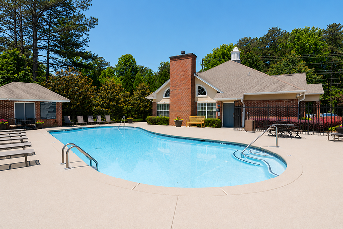 Inviting outdoor pool area with sun loungers and lush greenery, perfect for relaxation and leisure.