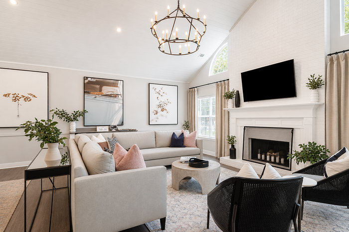 Elegant living room with modern chandelier, cozy sectional sofa, and stylish decor in a bright, inviting space.