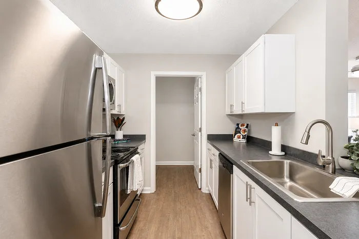 Modern kitchen with sleek stainless steel appliances, elegant white cabinetry, and spacious countertops.