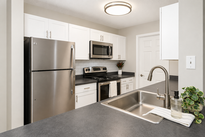 Modern kitchen with sleek stainless steel appliances, elegant white cabinetry, and a stylish open counter layout.