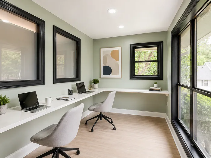 Bright and modern home office with wide windows, sleek workstations, and tasteful decor creating an inspiring workspace.