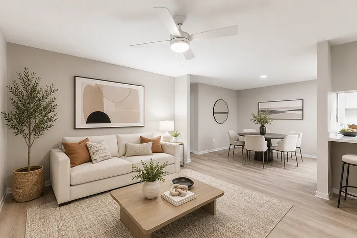 Chic and inviting living-dining area featuring a cozy beige sofa, modern artwork, and a stylish dining set, framed by elegant light wood flooring and soft lighting.