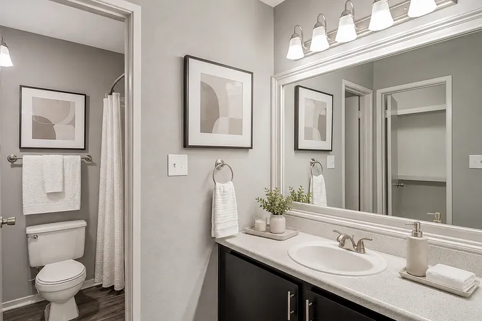 Contemporary bathroom with elegant vanity, framed artwork, and soft lighting, showcasing sophisticated design.