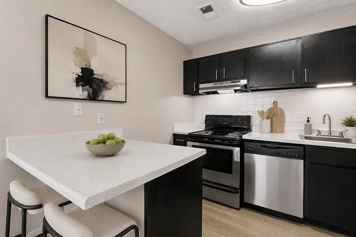 Modern kitchen with sleek black cabinets, elegant countertops, and a cozy breakfast bar, enhanced by chic artwork and stainless steel appliances.