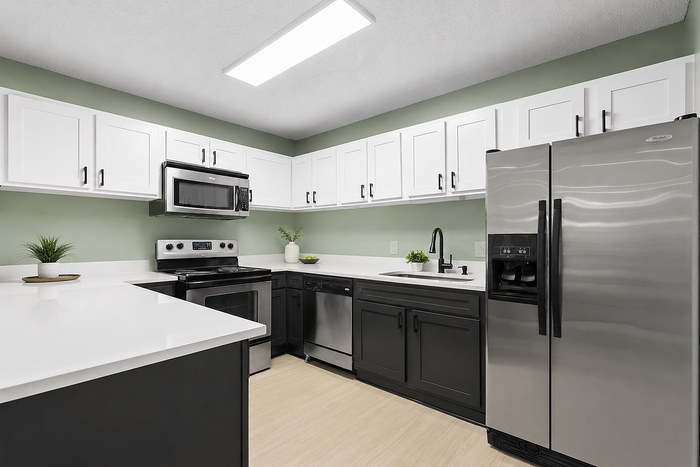 Modern kitchen with sleek stainless steel appliances, white and charcoal cabinets, and elegant quartz countertops.
