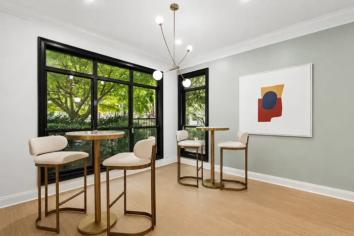 Bright and modern dining area with chic bar stools, stunning floor-to-ceiling windows, and contemporary art, ideal for stylish gatherings.