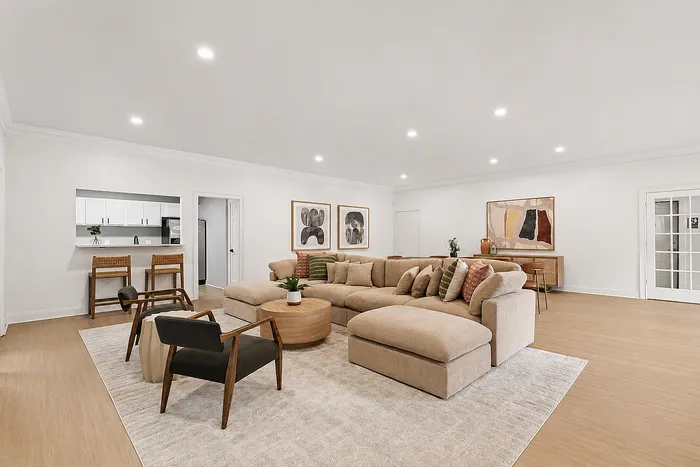 Spacious and inviting living room with modern neutral decor, plush sectional sofa, and chic artwork, perfect for relaxation and entertaining.