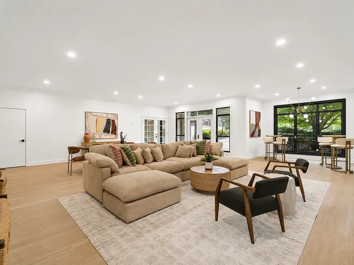 Spacious and inviting living room with modern neutral decor, plush sectional sofa, and chic artwork, perfect for relaxation and entertaining.