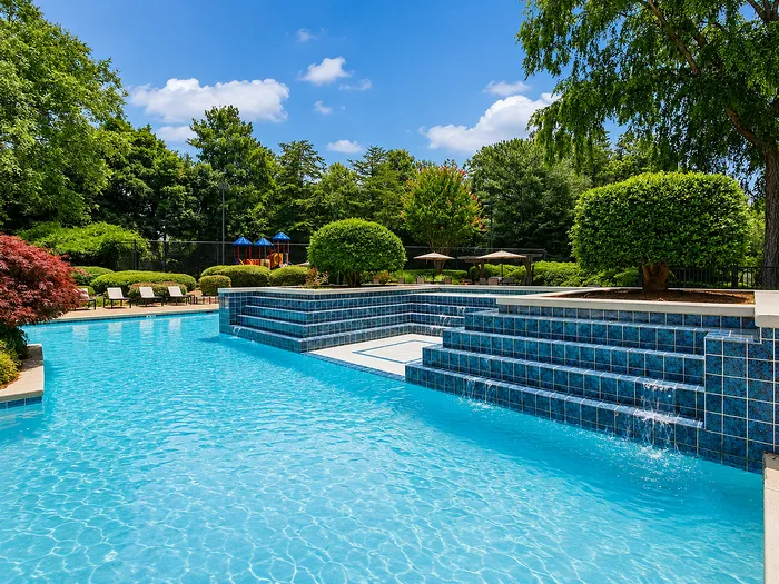 Inviting outdoor pool with stunning water features and lush greenery, perfect for relaxation and leisure.