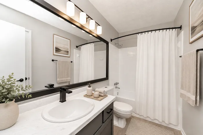 Elegant bathroom with modern fixtures, a sleek vanity with a large mirror, and a relaxing tub-shower combination.