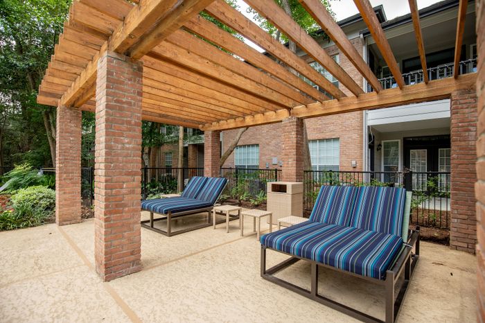 Charming outdoor lounge area with stylish pergola and cozy seating, ideal for relaxation and enjoying nature.